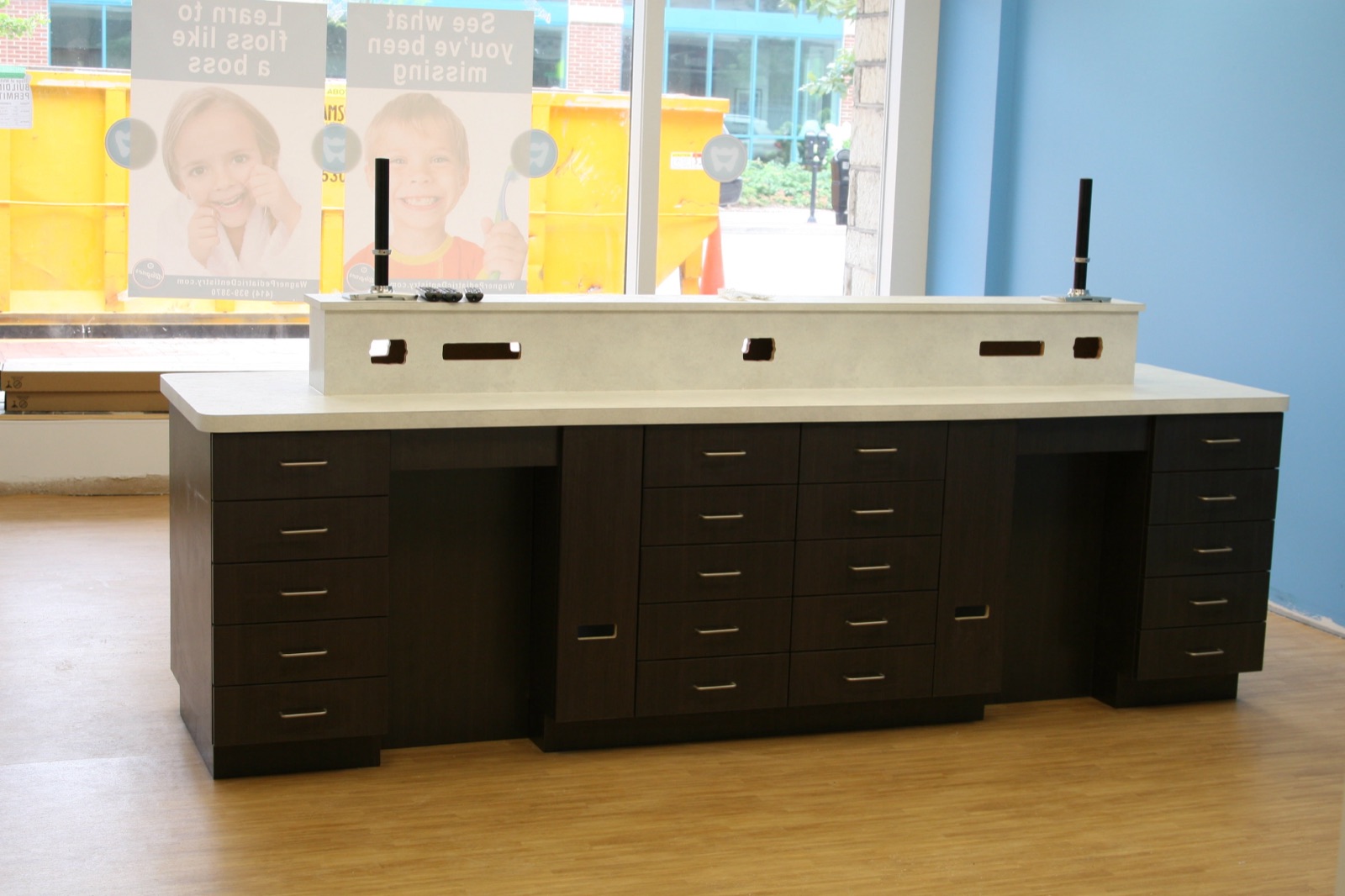 Espresso-finish custom casework with solid surface top in a dental office