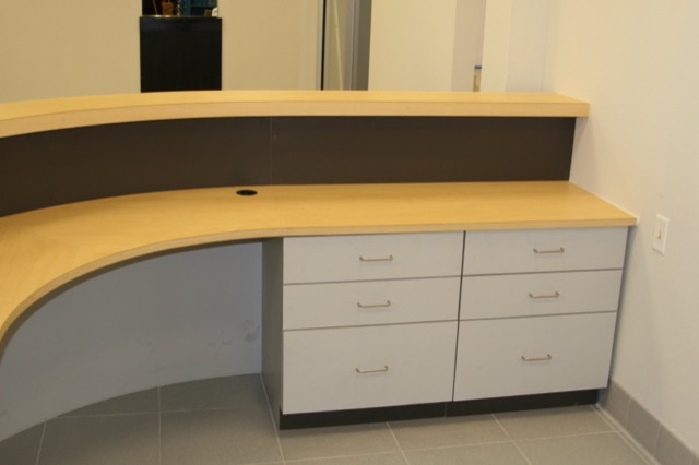 Curved maple reception desk with drawer banks