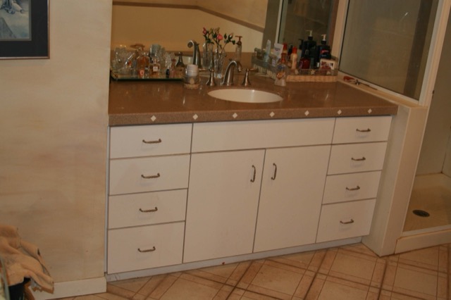 White bathroom vanity with solid surface top and tile-inlay edge
