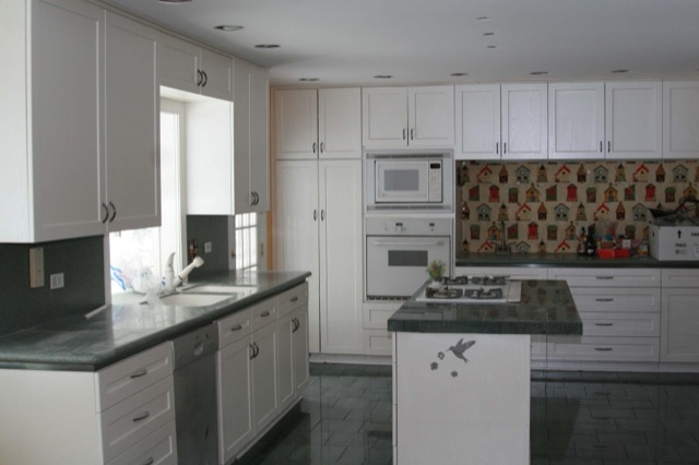 White kitchen with full-height pantry cabinets and center island