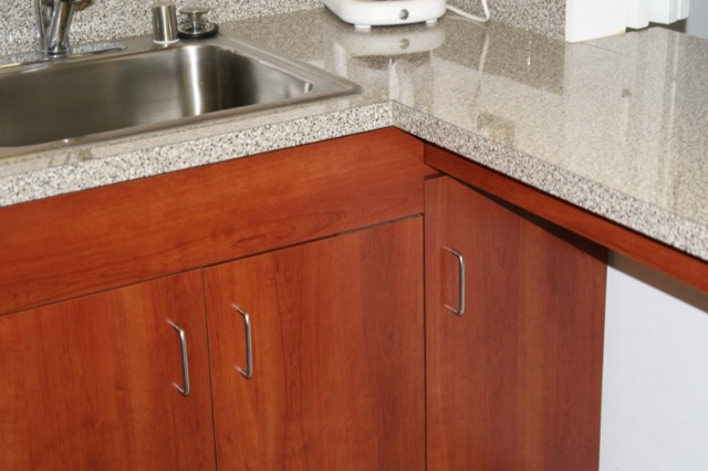 Cherry break-room cabinets with granite-look countertop and sink