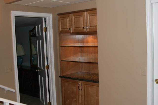 Recessed hallway built-in with glass shelves and lighting
